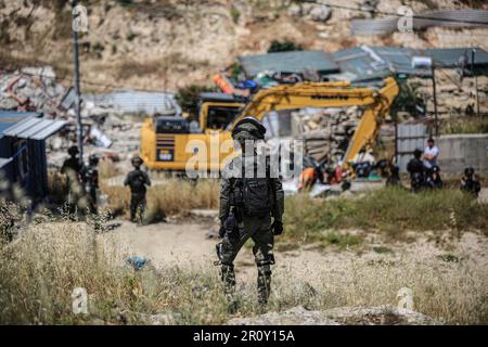 Jerusalem, Israel. 10. Mai 2023. Israelische Soldaten stehen Wache, während Bulldozer eine Abbruchoperation im Stadtviertel Jabal Mukaber in Ostjerusalem durchführen. Schwere Maschinen der Gemeinde zerstörten zwei Häuser im Gebiet "Khilat al-Abed" in der Stadt Jabal-Mukaber östlich von Jerusalem, die den Brüdern Firas und Ali Shuqairat gehörten, unter dem Vorwand, keine Genehmigung zu erhalten. Kredit: SOPA Images Limited/Alamy Live News Stockfoto