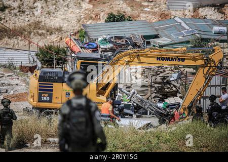 Jerusalem, Israel. 10. Mai 2023. Israelische Soldaten stehen Wache, während Bulldozer eine Abbruchoperation im Stadtviertel Jabal Mukaber in Ostjerusalem durchführen. Schwere Maschinen der Gemeinde zerstörten zwei Häuser im Gebiet "Khilat al-Abed" in der Stadt Jabal-Mukaber östlich von Jerusalem, die den Brüdern Firas und Ali Shuqairat gehörten, unter dem Vorwand, keine Genehmigung zu erhalten. Kredit: SOPA Images Limited/Alamy Live News Stockfoto