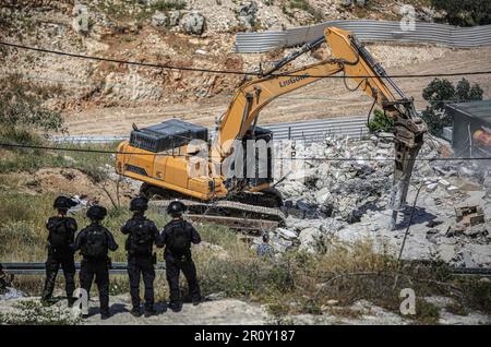 Jerusalem, Israel. 10. Mai 2023. Israelische Soldaten stehen Wache, während Bulldozer eine Abbruchoperation im Stadtviertel Jabal Mukaber in Ostjerusalem durchführen. Schwere Maschinen der Gemeinde zerstörten zwei Häuser im Gebiet "Khilat al-Abed" in der Stadt Jabal-Mukaber östlich von Jerusalem, die den Brüdern Firas und Ali Shuqairat gehörten, unter dem Vorwand, keine Genehmigung zu erhalten. Kredit: SOPA Images Limited/Alamy Live News Stockfoto