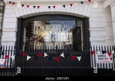 Savile Row, die vor der Krönung am 06. 2023. Mai Boutiquen mit modischer Kleidung und Schaufenstern für König Karl III. Zusammenstellt. Stockfoto