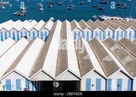Cascais, Portugal - Oktober 2022; Panoramablick über Holzschuppen, weiß-blau gestreift am Kai im Hafen der Stadt Stockfoto