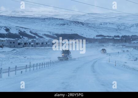 Route 1, Island-Februar 2022; Sicht des Fahrers auf die Hauptstraße rund um Island mit Schneepflügen auf der anderen Seite des eingezäunten Mediums Stockfoto