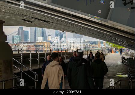 LONDON - 21. April 2023: Die Silhouette der Fußgänger unter der Blackfriars Bridge bildet einen dramatischen Kontrast zur modernen Architektur von Stockfoto