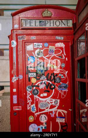 LONDON - 21. April 2023: Erkunden Sie die ikonischen Symbole der Londoner urbanen Kunstszene mit einem Besuch einer traditionellen britischen Telefonzelle mit Graffiti Stockfoto