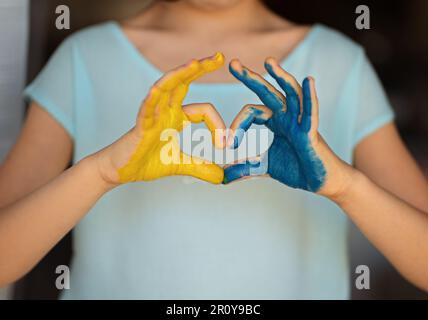 Kinderhände auf Farben der ukrainischen Flagge gemalt. Frieden für die Ukraine. Beenden Sie den Krieg in der Ukraine. Ich liebe das Ukraine-Konzept. Gelb und blau. Kinderhände in Form Stockfoto