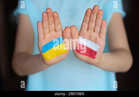 Hände, die in die Flaggen der Ukraine und Russlands gemalt sind ..., image size:450x316