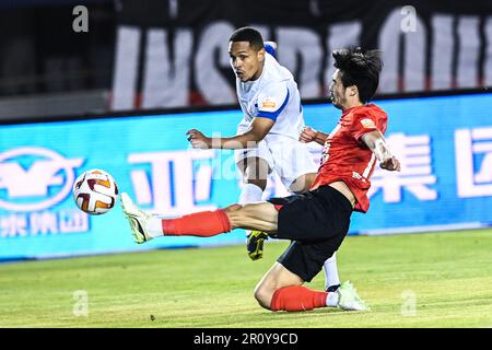 Peking, China. 10. Mai 2023. Rodrigo Henrique (L) von Meizhou Hakka schießt am 10. Mai 2023 während eines 2023. Rennens der Chinese Football Association Super League (CSL) mit 6. Runden zwischen Changchun Yatai und Meizhou Hakka in Changchun in der nordchinesischen Provinz Jilin. Kredit: Yan Linyun/Xinhua/Alamy Live News Stockfoto