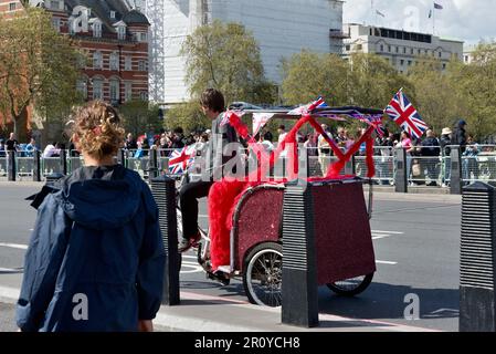 Eine Londoner Rikscha oder ein Fahrradfahrer, die an einem sonnigen Frühlingstag im Zentrum von London, England, Großbritannien und Nordirland auf der Westminster Bridge mit Touristen überfüllt ist Stockfoto