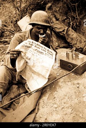 PFC. Clarence Whitmore, Stimme Funker, 24. Infanterie-Regiment, liest die neueste Nachrichten und Chow bei Flaute in der Schlacht, in der Nähe von Sangju, Korea genießen.  9. August 1950.  Foto von Pfc. Charles Fabiszak, Armee. (USIA) Stockfoto