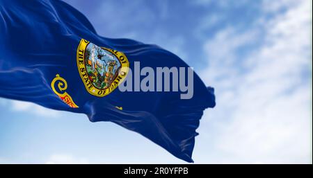 Idaho Staatsflagge flattert im Wind. Blauer Hintergrund mit Staatssiegel und roter Streifen mit goldenem Text des Bundesstaats Idaho. Rendern der 3D-Darstellung. Stockfoto