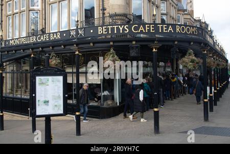 Eine lange Schlange von Kunden wartet auf einen Sitzplatz in Betty's Tea Rooms in Harrogate, North Yorkshire Stockfoto