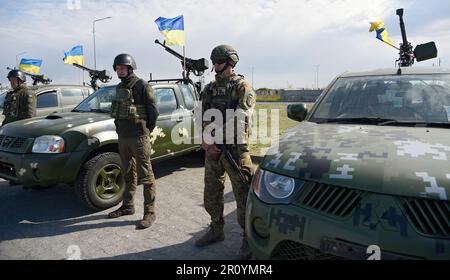 REGION KIEW, UKRAINE - 10. MAI 2023 - ukrainische Soldaten werden von Geländewagen, die vom Kommandeur der Gemeinsamen Streitkräfte der Streitkräfte von geleitet werden, aufmerksam verfolgt Stockfoto