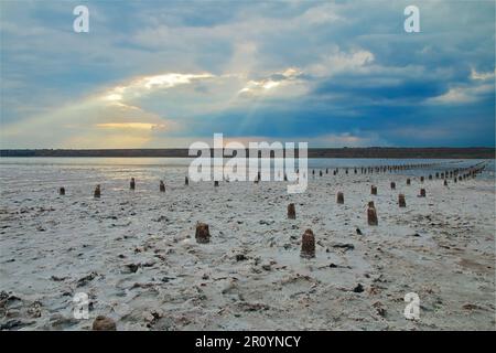 Das Foto wurde in der Ukraine in der Nähe der Stadt Odessa aufgenommen. Das Bild zeigt eine Landschaft einer salzigen Flussmündung namens Kuyalnik. Ein Sonnenstrahl durchbohrt Stockfoto