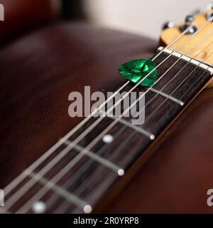 Green Guitar Pick in Guitar Streicher Stockfoto
