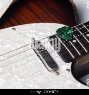 Green Guitar Pick in Guitar Streicher Stockfoto