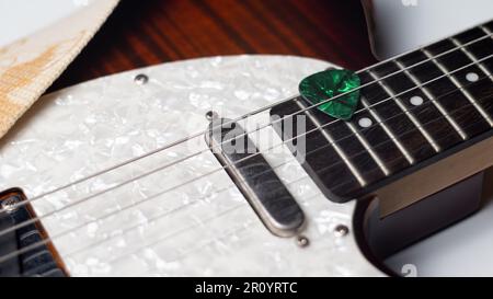 Green Guitar Pick in Guitar Streicher Stockfoto