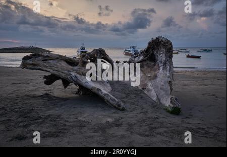 Pantai Jerman (deutscher Strand) in Kuta, Bali Indonesien, Sonnenuntergangsaufnahme, bei der Boote im Ozean gezeigt werden, während Menschen den Strand genießen Stockfoto