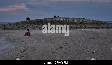 Pantai Jerman (deutscher Strand) in Kuta, Bali Indonesien bei Sonnenuntergang, bei dem die Leute den Strand genießen Stockfoto