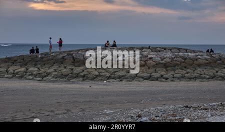 Pantai Jerman (deutscher Strand) in Kuta, Bali Indonesien bei Sonnenuntergang, bei dem die Leute den Strand genießen Stockfoto