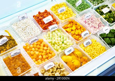 Gekühlte Scheiben Obst und Gemüse auf einer Ladentheke Stockfoto