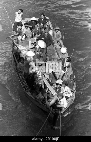 Ein Boot mit 35 vietnamesische Flüchtlinge kommt an der Seite der amphibischen Kommando Schiff USS BLUE RIDGE (LCC-19). Die Flüchtlinge wurden gerettet 350 Meilen nordöstlich von Cam Ranh Bay, Vietnam, nach acht Tagen am Meer in einem 35-Fuß-Boot. Stockfoto