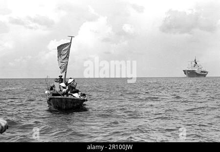 Ein 35-Fuß-Boot nähert sich dem Amphibischen Kommando Schiff USS BLUE RIDGE (LCC 19). Die Blue Ridge gerettet 35 refugeees 350 Meilen nordöstlich von Cam Ranh Bay, Vietnam, nach hatten Sie verbringen 8 Tage auf See im Boot. Stockfoto