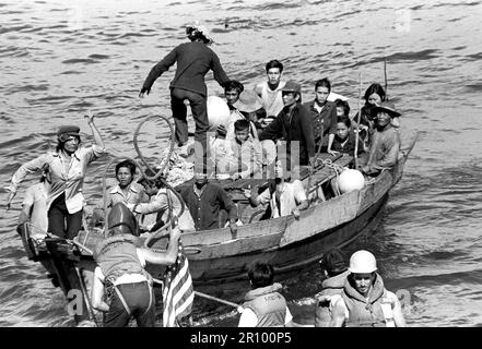 Eine Linie ist mit einem 35-Fuß-Boot von der USS BLUE RIDGE (LCC 19) Besatzungsmitglieder in einem Rettungsboot gesichert. Die amphibischen Kommando Schiff gerettet 35 vietnamesische Flüchtlinge 350 Meilen nordöstlich von Cam Ranh Bay, Vietnam, nach hatten Sie verbringen 8 Tage auf See. Sie waren nach Hongkong transportiert. Stockfoto