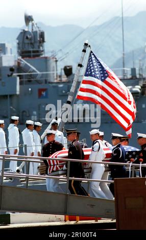 Eine gemeinsame Dienstleistungen Schatulle Team trägt die Fahne - drapierte Schatulle der Unbekannte Soldat der Vietnam ära auf der Fregatte USS BREWTON (FF 1086), bei Abschluss eines Kranzniederlegung. Der Sarg wird zu Kalifornien transportiert werden und dann auf dem Arlington National Cemetery übertragen zu beerdigen, am Grab des Unbekannten. Stockfoto