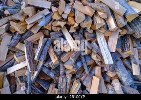 Ein Stapel Holz, das für die Heizung des Hauses vorbereitet wurde. Feuerholz für die Heizung im Winter. Gehacktes Feuerholz. Stockfoto