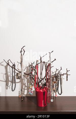 Der originale Halter für Schmuck in Form eines Baumes, handgefertigt. Produkte mit Dekorationen auf der Kommode. Inneneinrichtung, originelle Idee. clos Stockfoto