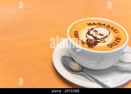 nagasaki, kyushu - 14 2022. dez.: Cappuccino-Kaffeetasse mit Zimtpulver Schablone Kunst einer Karikatur des schottischen Händlers Thomas Blake Glover Stockfoto