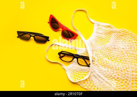 Tragetasche mit stilvoller Sonnenbrille auf gelbem Hintergrund Stockfoto