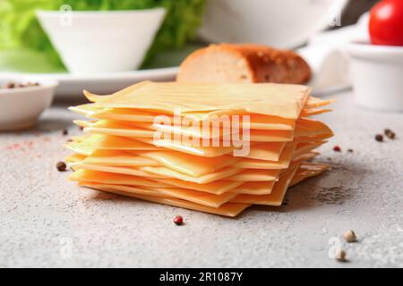 Scheiben von leckerem Schmelzkäse auf dem Tisch Stockfoto