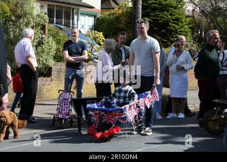 Familien, die am Wheelbarrow Race bei der Street Party teilnehmen, um König Charles III. Krönung Surrey England zu feiern Stockfoto