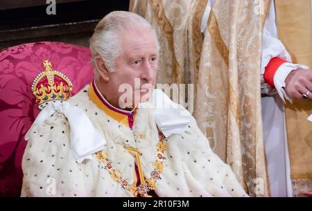 König Karl III. Krönung, in zeremoniellen Gewändern sitzend, ernsthaft im Nachdenken, mit seiner zukünftigen Verantwortung als Monarch vor ihm, während der Krönungszeremonie in Westminster Abbey Westminster London, UK, am 6. Mai 2023 Stockfoto