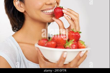 Ersetze stattdessen die Schüssel mit Eiscreme. Eine junge Frau genießt eine Schüssel Erdbeeren. Stockfoto