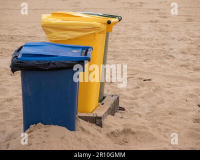 Saubere und nachhaltige Strände: Bedeutung bunter Recyclingbehälter Stockfoto