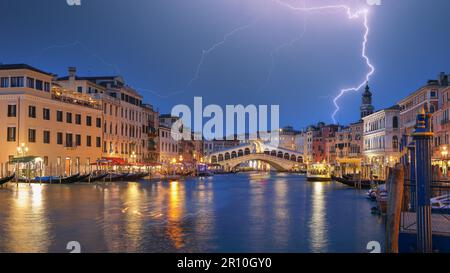 Atemberaubende Blitze am Nachthimmel über der Stadt Venedig mit dem berühmten Canal Grande und der Rialtobrücke. Beliebtes Reiseziel. Lage: Venedig, Venet Stockfoto