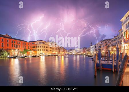 Atemberaubende Blitze am Nachthimmel über der Stadt Venedig mit dem berühmten Canal Grande und der Rialtobrücke. Beliebtes Reiseziel. Lage: Venedig, Venet Stockfoto