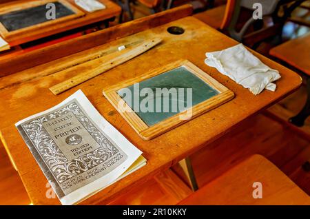 Im Little Red Schoolhouse im Baldwin County Bicentennial Park, 22. April 2023 in Stockton, Alabama, ist ein alter Schreibtisch abgebildet. Stockfoto