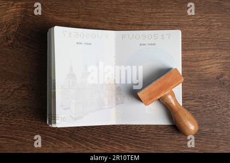 Ukraine, Lemberg - 6. September 2022: Pass- und Visummarke auf Holztisch, Draufsicht Stockfoto