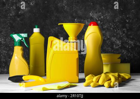 Fahrzeugreinigungsprodukte, Handschuhe und gelber Behälter mit Motoröl Stockfoto