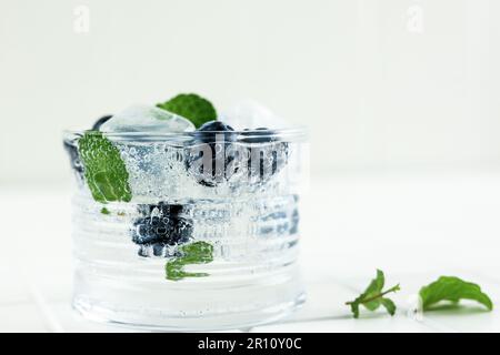 Nahaufnahme Blueberry Mojito Cocktail mit Minzblättern auf weißem Hintergrund. Stockfoto