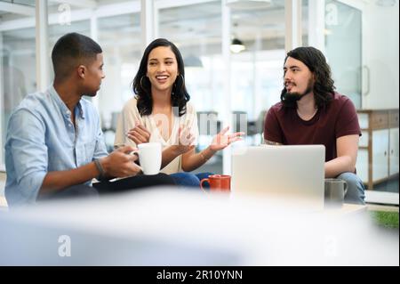 Entschlossen, die kreative Landschaft zu einem Trio zu machen. Eine Gruppe von Geschäftsleuten, die sich in einem Büro unterhalten. Stockfoto