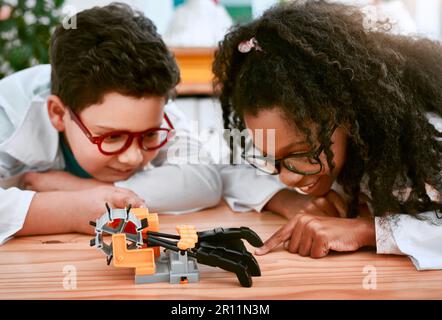 Ingenieurwesen, Lernen und Kinder bauen in der Schule eine Roboterhand zusammen und sind neugierig. Kluge, ausgebildete und junge Ingenieurin Stockfoto