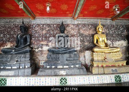 Buddha-Statuen in den Gängen rund um das größte Heiligtum in Wat Suthat, Bangkok, Thailand. Stockfoto