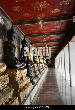 Buddha-Statuen in den Gängen rund um das größte Heiligtum in Wat Suthat, Bangkok, Thailand. Stockfoto