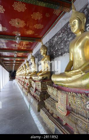 Buddha-Statuen in den Gängen rund um das größte Heiligtum in Wat Suthat, Bangkok, Thailand. Stockfoto