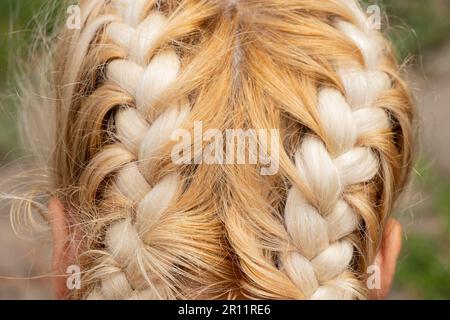 Geflochtener Stachel auf dem Kopf eines jungen blonden Mädchens Stockfoto