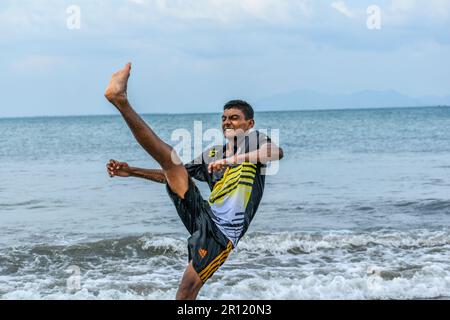 Bengali-Junge, der am Strand einen Fahrrad-Kick auf Meerwasser vorführt Stockfoto
